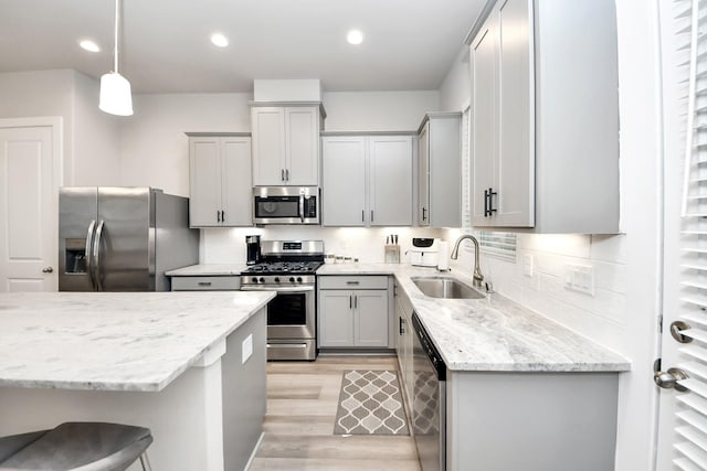 9016 Lonestar River Ln, Houston, TX 77080 - kitchen featuring stainless steel appliances, gray cabinetry, light wood-type flooring, light stone counters, and pendant lighting
