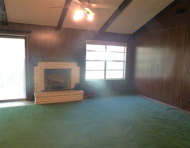 415 N Atchison St, Sealy, TX 77474 - unfurnished living room with wood walls, a ceiling fan, a fireplace, plenty of natural light, and carpet