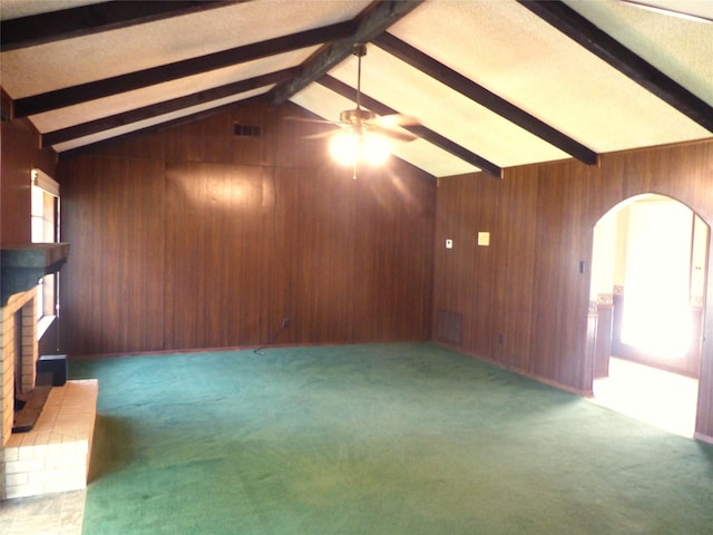 415 N Atchison St, Sealy, TX 77474 - unfurnished living room with arched walkways, a ceiling fan, wooden walls, a brick fireplace, and carpet flooring