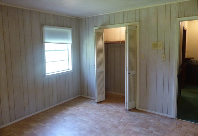 415 N Atchison St, Sealy, TX 77474 - unfurnished bedroom featuring a closet, wood walls, and crown molding