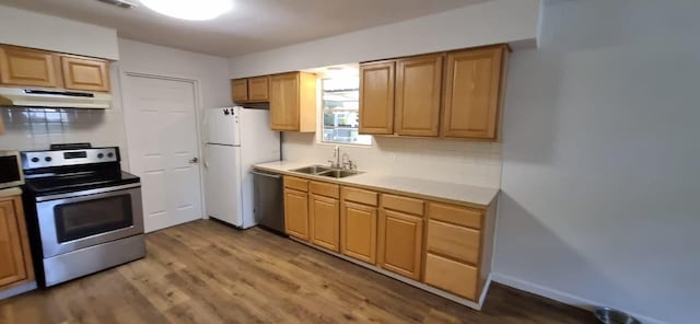 10626 Fussel Rd, Conroe, TX 77385 - kitchen with appliances with stainless steel finishes, under cabinet range hood, tasteful backsplash, and wood finished floors