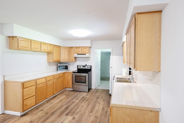 10626 Fussel Rd, Conroe, TX 77385 - kitchen with appliances with stainless steel finishes, light brown cabinets, tile countertops, and light wood-style flooring
