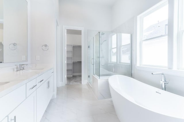 819 Bringhurst, Houston, TX 77020 - bathroom with a stall shower, marble look tile flooring, a soaking tub, double vanity, and a walk in closet
