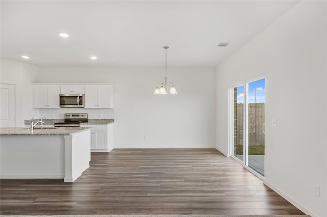 27214 Leeward Jetty Dr, Katy, TX 77493 - kitchen with appliances with stainless steel finishes, light stone counters, a chandelier, white cabinetry, and recessed lighting