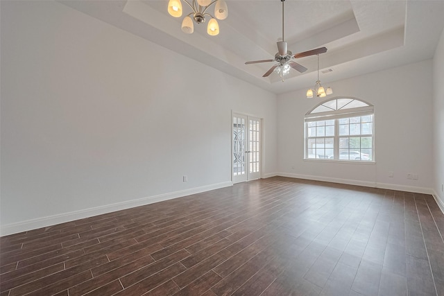 2403 Ranna Ct, Sugar Land, TX 77498 - spare room with a chandelier, a tray ceiling, dark wood-style flooring, and ceiling fan