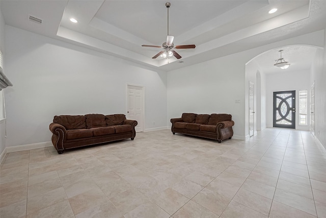 2403 Ranna Ct, Sugar Land, TX 77498 - living room with arched walkways, a ceiling fan, a tray ceiling, light tile patterned flooring, and recessed lighting