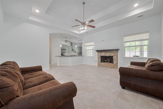 2403 Ranna Ct, Sugar Land, TX 77498 - living room with a ceiling fan, a raised ceiling, a fireplace, recessed lighting, and light tile patterned flooring
