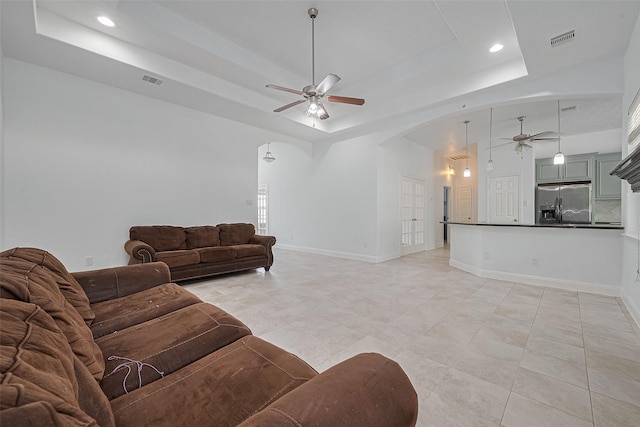 2403 Ranna Ct, Sugar Land, TX 77498 - living area with a ceiling fan, a raised ceiling, arched walkways, recessed lighting, and light tile patterned flooring
