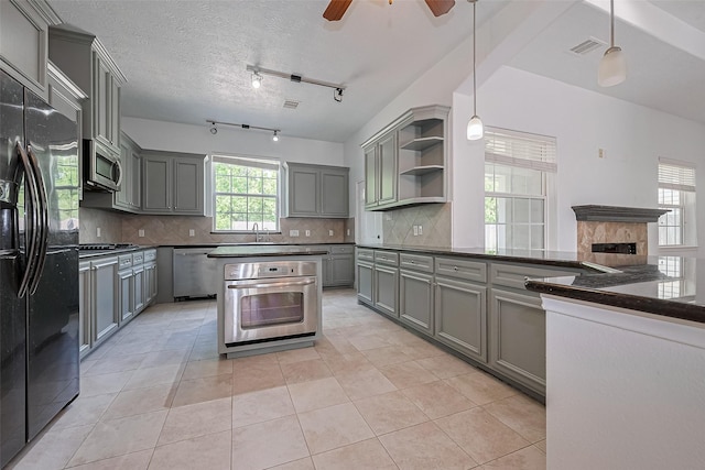 2403 Ranna Ct, Sugar Land, TX 77498 - kitchen with stainless steel appliances, gray cabinetry, open shelves, and tasteful backsplash