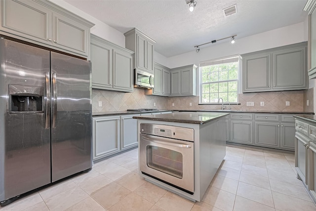 2403 Ranna Ct, Sugar Land, TX 77498 - kitchen with stainless steel appliances, gray cabinets, light tile patterned floors, and a textured ceiling