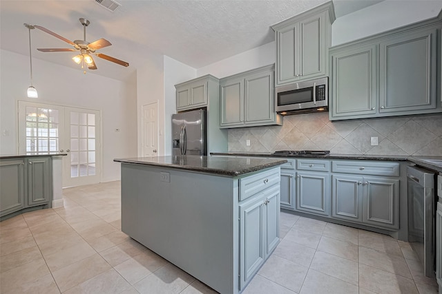 2403 Ranna Ct, Sugar Land, TX 77498 - kitchen with appliances with stainless steel finishes, a kitchen island, decorative backsplash, and light tile patterned floors