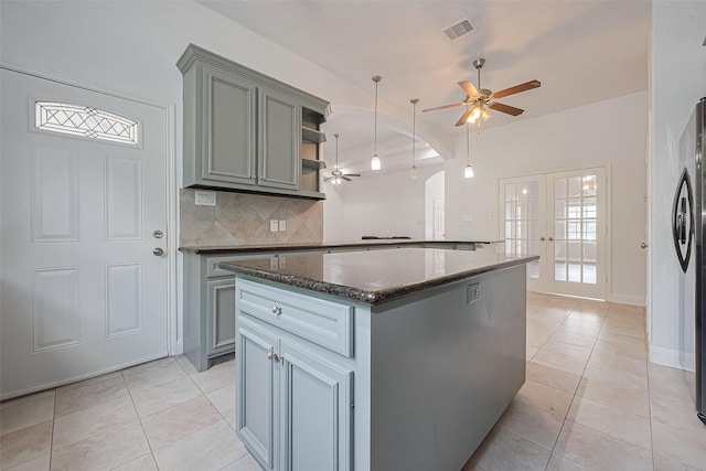 2403 Ranna Ct, Sugar Land, TX 77498 - kitchen with ceiling fan, light tile patterned floors, a kitchen island, and backsplash