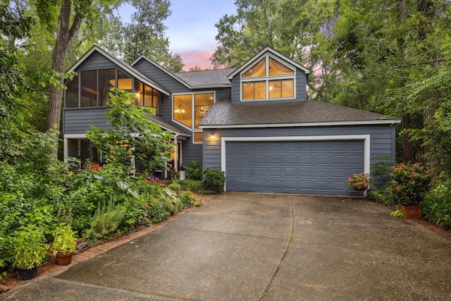 11 Leaf Trace Ct, Spring, TX 77381 - view of front facade featuring driveway, roof with shingles, a garage, and a sunroom