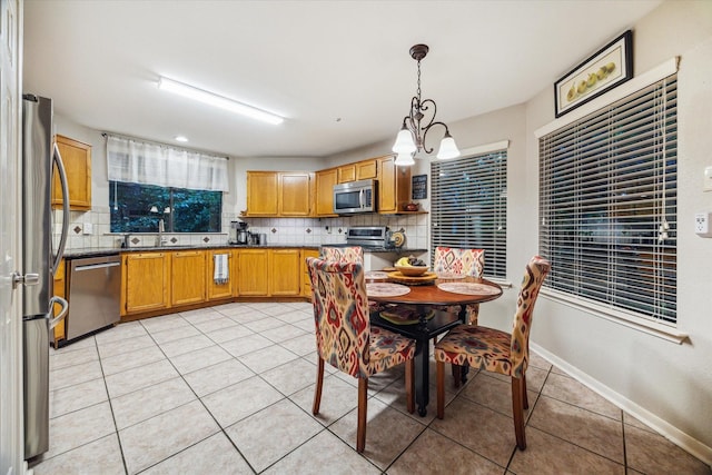 11 Leaf Trace Ct, Spring, TX 77381 - kitchen with stainless steel appliances, light tile patterned floors, backsplash, and dark countertops