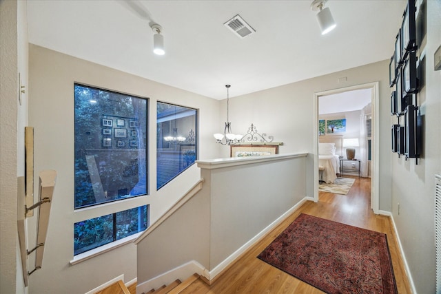11 Leaf Trace Ct, Spring, TX 77381 - hallway with wood finished floors, an upstairs landing, and a chandelier