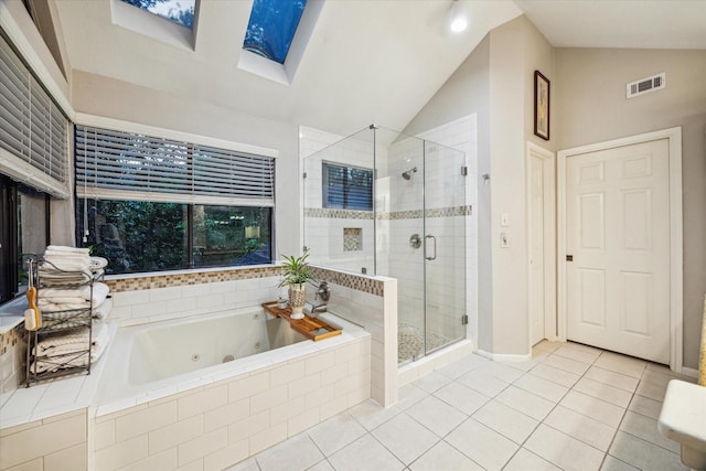 11 Leaf Trace Ct, Spring, TX 77381 - bathroom with vaulted ceiling, a tub with jets, tile patterned floors, a shower stall, and a skylight