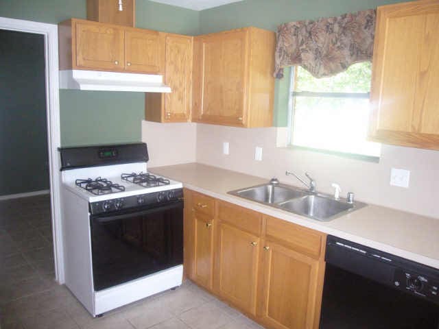 11514 Musetta Ct, Cypress, TX 77429 - kitchen featuring white range with gas cooktop, black dishwasher, under cabinet range hood, and light countertops