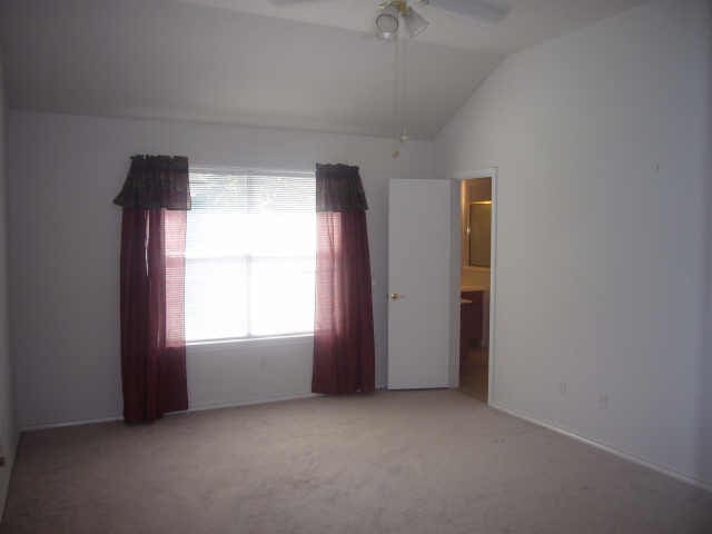 11514 Musetta Ct, Cypress, TX 77429 - carpeted empty room featuring lofted ceiling and ceiling fan