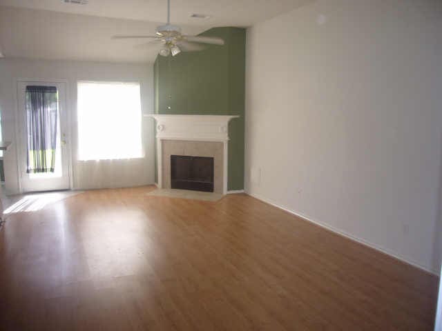 11514 Musetta Ct, Cypress, TX 77429 - unfurnished living room featuring a fireplace with flush hearth, a ceiling fan, and light wood-type flooring
