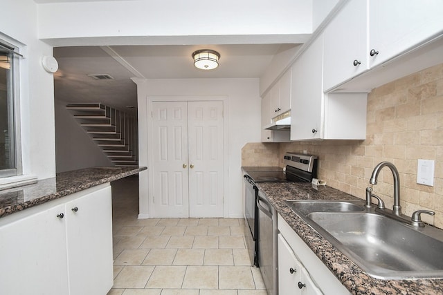2635 Marilee Ln Unit 2635, Houston, TX 77057 - kitchen featuring under cabinet range hood, stainless steel appliances, white cabinetry, decorative backsplash, and light tile patterned floors