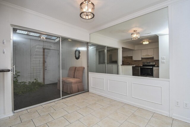 2635 Marilee Ln Unit 2635, Houston, TX 77057 - kitchen with stainless steel range with electric stovetop, crown molding, under cabinet range hood, tasteful backsplash, and gray cabinetry