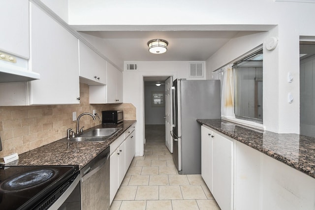 2635 Marilee Ln Unit 2635, Houston, TX 77057 - kitchen featuring black appliances, white cabinetry, backsplash, dark stone countertops, and light tile patterned floors