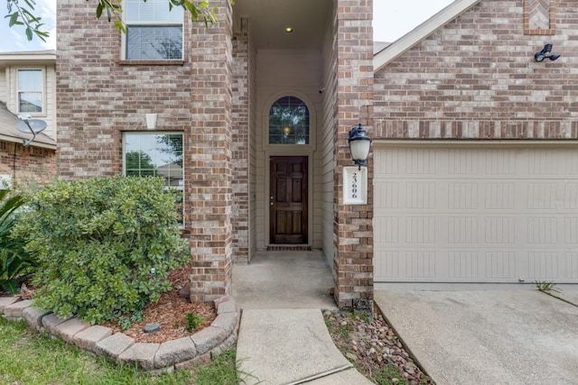 23606 Stargazer Pt, Spring, TX 77373 - property entrance featuring brick siding, an attached garage, and concrete driveway