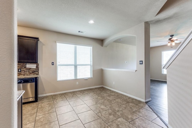 23606 Stargazer Pt, Spring, TX 77373 - unfurnished dining area with a ceiling fan, a textured ceiling, arched walkways, and light tile patterned floors
