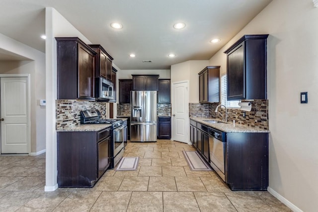 23606 Stargazer Pt, Spring, TX 77373 - kitchen featuring stainless steel appliances, light stone counters, tasteful backsplash, dark brown cabinetry, and recessed lighting