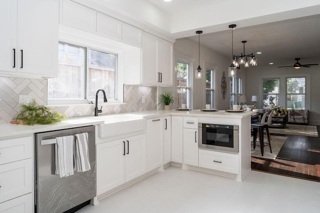 1020 E 16th St, Houston, TX 77009 - kitchen with stainless steel appliances, a peninsula, plenty of natural light, white cabinetry, and recessed lighting