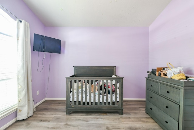 2526 Hidden Park Ln, Conroe, TX 77385 - bedroom with wood finished floors, a crib, and vaulted ceiling