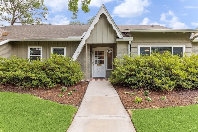 10050 Locke Ln, Houston, TX 77042 - view of exterior entry with board and batten siding and a shingled roof