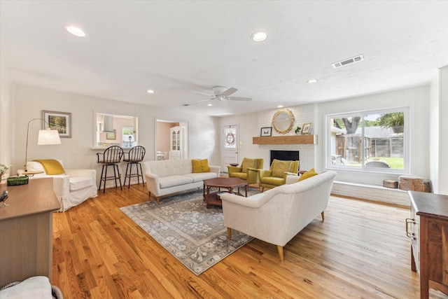 10050 Locke Ln, Houston, TX 77042 - living room featuring plenty of natural light, wood finished floors, ceiling fan, recessed lighting, and a brick fireplace