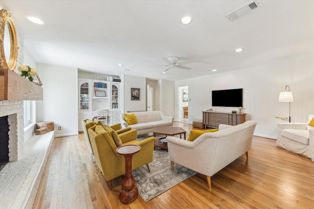 10050 Locke Ln, Houston, TX 77042 - living room featuring light wood-style floors, ceiling fan, a brick fireplace, and recessed lighting