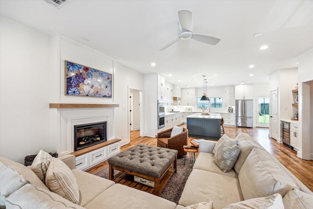 1247 Martin St, Houston, TX 77018 - living area with wine cooler, ceiling fan, light wood finished floors, recessed lighting, and a glass covered fireplace