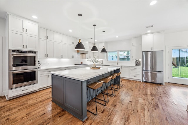 1247 Martin St, Houston, TX 77018 - kitchen featuring stainless steel appliances, plenty of natural light, white cabinets, and recessed lighting