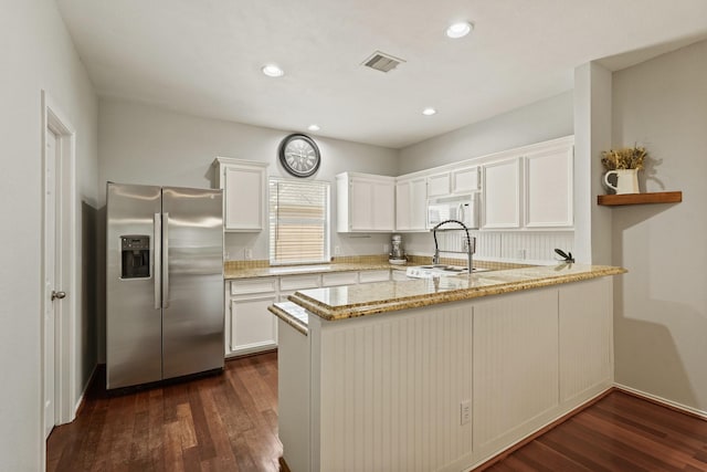 2911 Clay St, Houston, TX 77003 - kitchen with stainless steel fridge with ice dispenser, white microwave, a peninsula, light stone countertops, and white cabinets