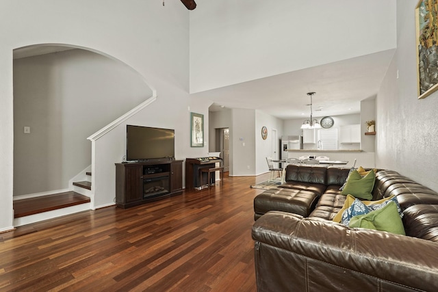 2911 Clay St, Houston, TX 77003 - living room with dark wood-type flooring, stairway, a towering ceiling, a ceiling fan, and arched walkways