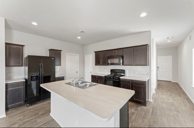 23322 Pelham Prairie Ln, Spring, TX 77373 - kitchen with black appliances, dark brown cabinets, light wood-style flooring, light countertops, and recessed lighting