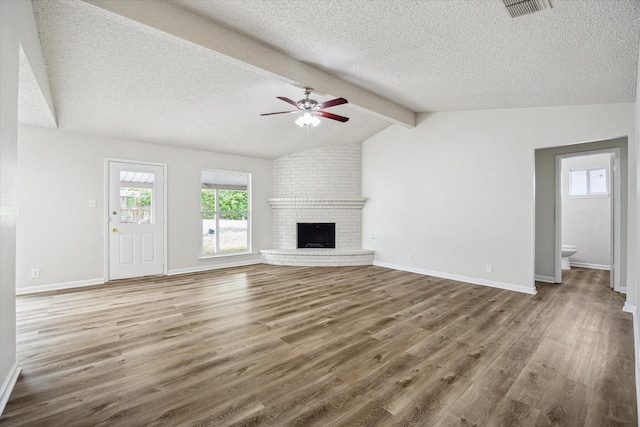 11331 Woollcott St, San Antonio, TX 78251 - unfurnished living room with a textured ceiling, wood finished floors, a ceiling fan, and a fireplace