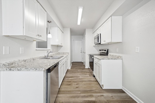 11331 Woollcott St, San Antonio, TX 78251 - kitchen with stainless steel appliances, light wood-type flooring, white cabinetry, and light countertops
