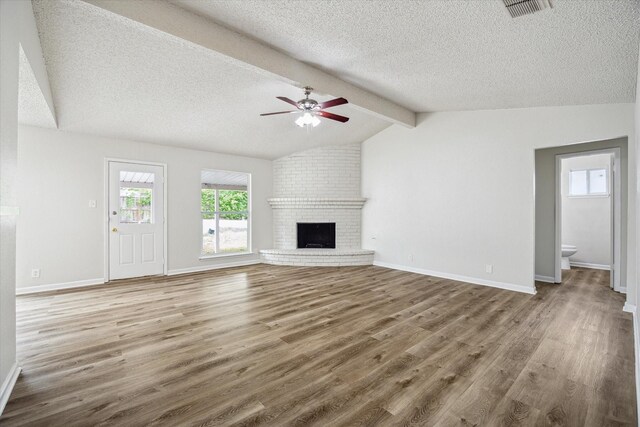 11331 Woollcott St, San Antonio, TX 78251 - unfurnished living room with a textured ceiling, wood finished floors, a ceiling fan, and a fireplace
