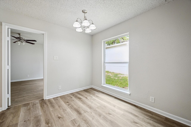 11331 Woollcott St, San Antonio, TX 78251 - unfurnished room with a chandelier, light wood-style floors, and a textured ceiling