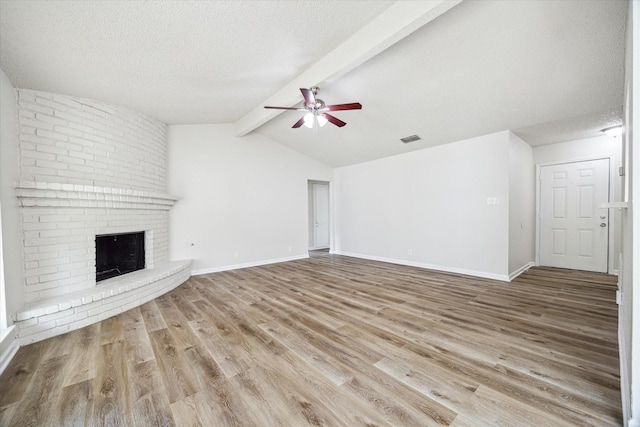 11331 Woollcott St, San Antonio, TX 78251 - unfurnished living room featuring wood finished floors, a ceiling fan, a textured ceiling, and a fireplace