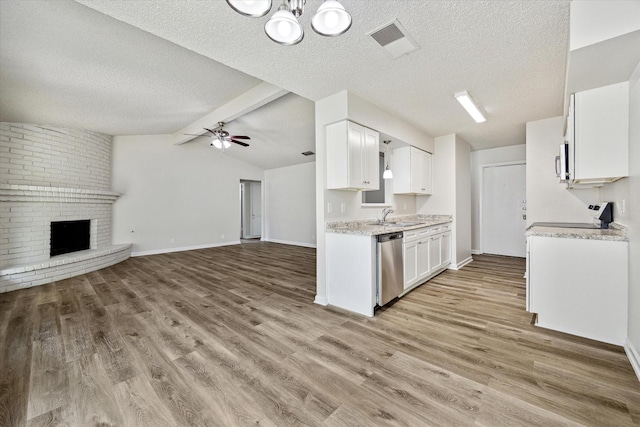 11331 Woollcott St, San Antonio, TX 78251 - kitchen featuring dishwasher, open floor plan, light wood finished floors, white cabinetry, and a textured ceiling