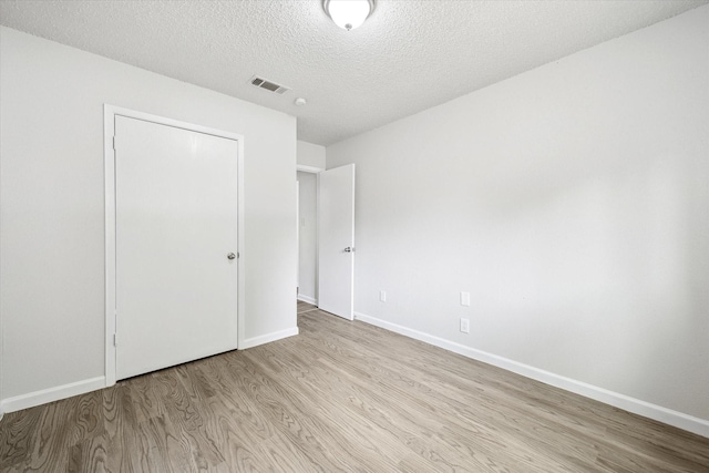 11331 Woollcott St, San Antonio, TX 78251 - unfurnished bedroom featuring wood finished floors and a textured ceiling