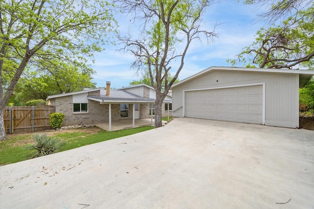 11331 Woollcott St, San Antonio, TX 78251 - mid-century modern home featuring a garage, concrete driveway, a chimney, and brick siding