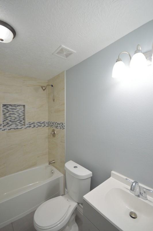 3007 Tuam St, Houston, TX 77004 - full bathroom with bathing tub / shower combination, vanity, and a textured ceiling