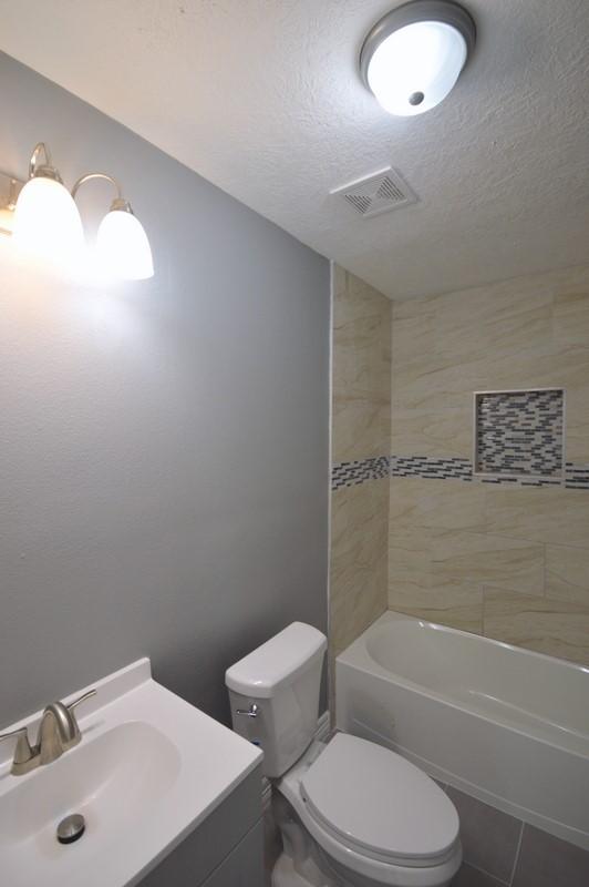 3007 Tuam St, Houston, TX 77004 - full bathroom with vanity, a textured ceiling, tub / shower combination, and tile patterned floors