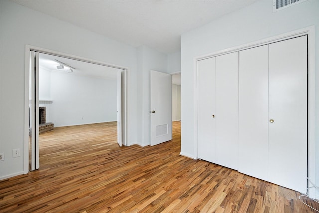 1100 Augusta Dr Unit 63, Houston, TX 77057 - unfurnished bedroom featuring wood finished floors, a fireplace, and a closet